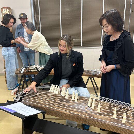 katho-Studierende erproben sich an einem japanischen Musikinstrument.