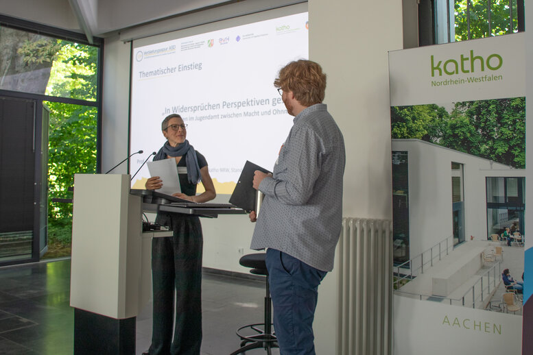 Julia Breuer-Nyhsen und Dominik Farrenberg stehen beide auf dem Podium der Aula
