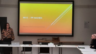 Eine Referentin steht vor einer Leinwand