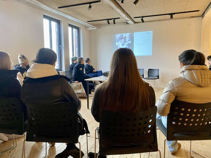 Schüler:innen hören bei einen Vortrag zu.