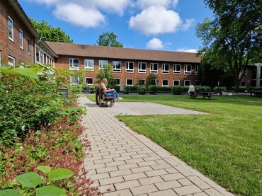 Es wird der Campus des Standorts Münster inkl. der Grünfläche davor gezeigt.