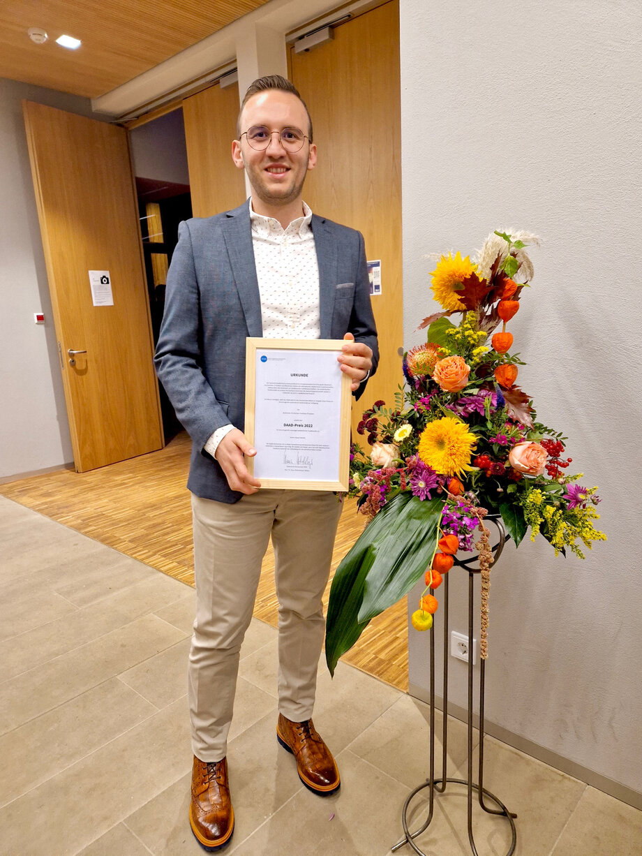 Ahmad Sabsabe zeigt seinen DAAD-Preis 2022 nach der Verleihung auf der Dienstbesprechung in Paderborn. 