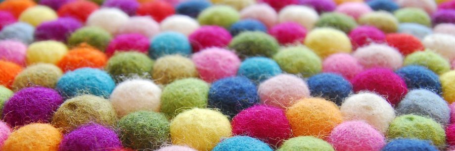 Fläche mit bunten Filzknäuel.