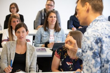 Professor Brühe in seitlicher Ansicht spricht zu Studierenden in Sitzreihen.