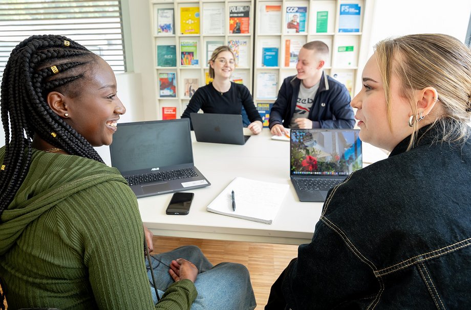 Studierende sitzen an einem Tisch und lernen.

