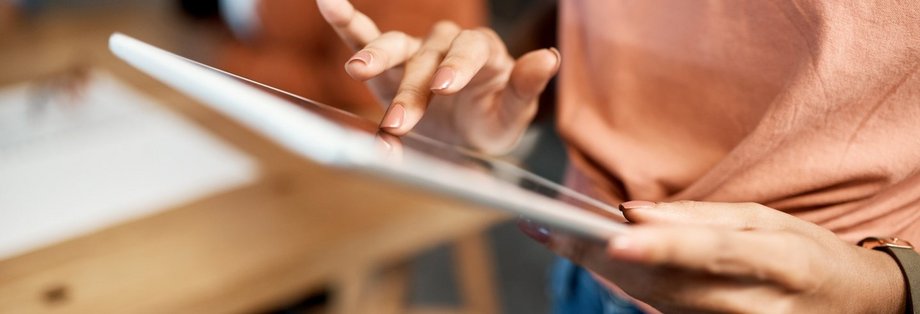 Eine Person hält ein Tablet in ihrer Hand.