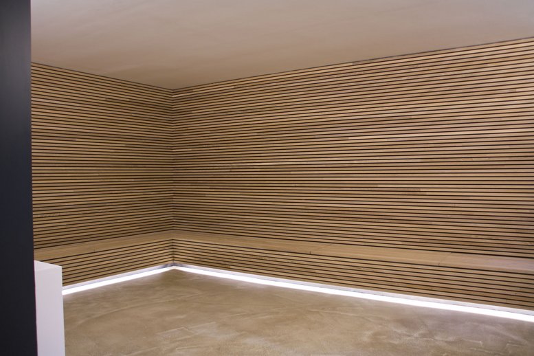 Raumwand und Bank aus warmen Holzpaneelen