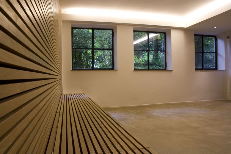 Raum mit warmen Holzpaneelen und drei Fenstern