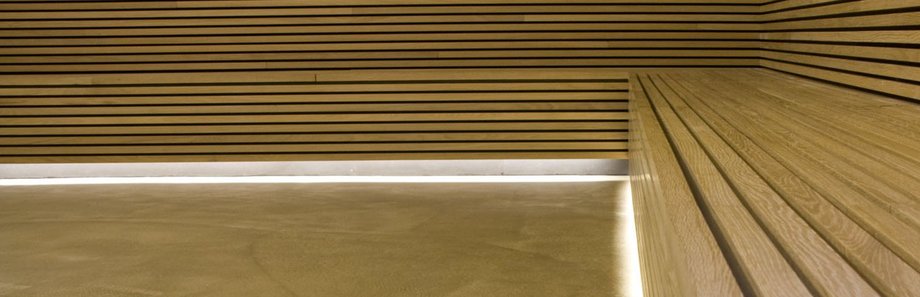 Raumwand und Bank aus warmen Holzpaneelen