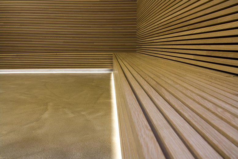 Raumwand und Bank aus warmen Holzpaneelen